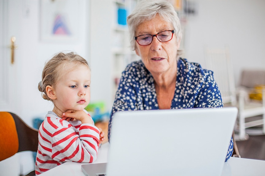 Grandmother and Granddaughter reviewing on a laptop