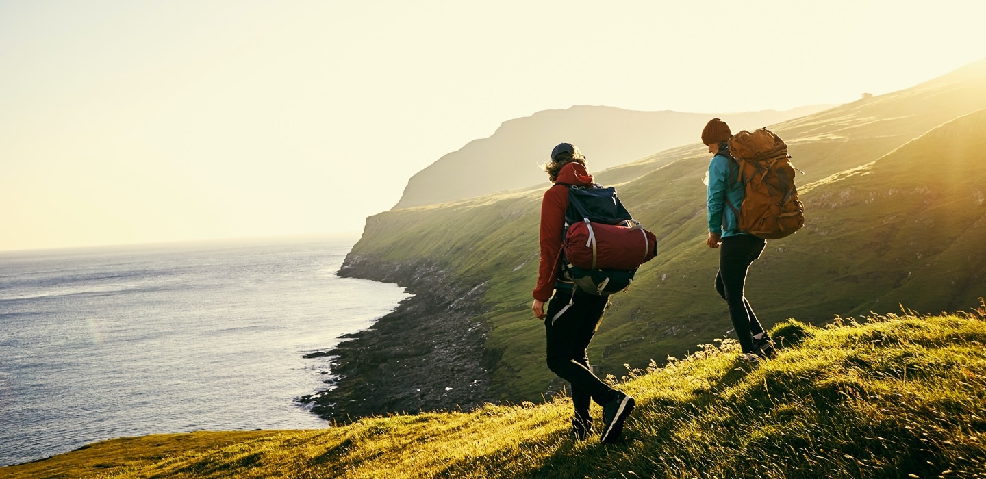 Two investors walking among sunlit hills 