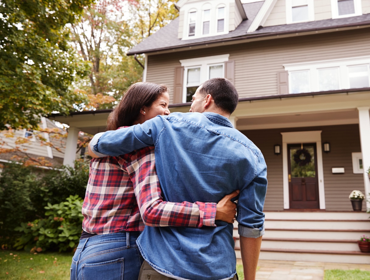 A happy couple approaching a house