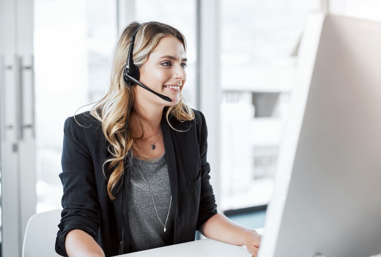 Female at desk with computer and headset 